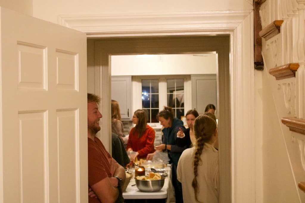 Friends gathered around a kitchen table in a warm home